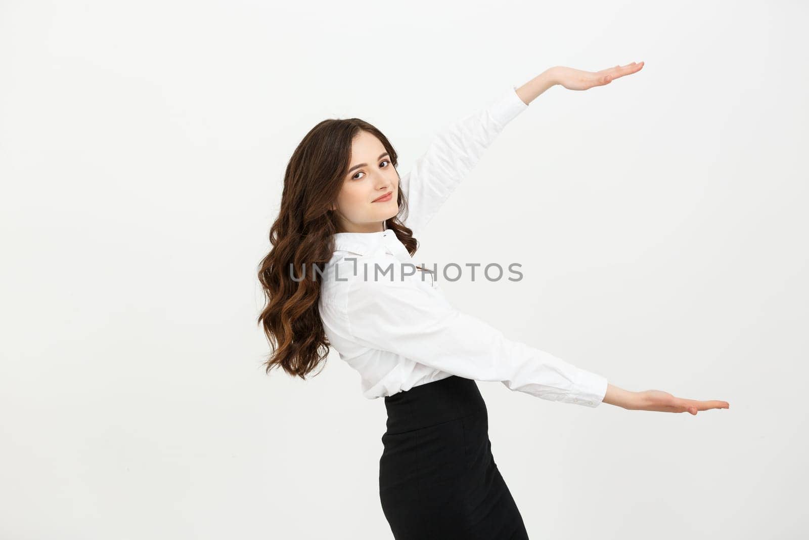 Advertisement concept. Portrait of gorgeous caucasian businesswoman showing two hands on copy space on grey background, presenting new product.