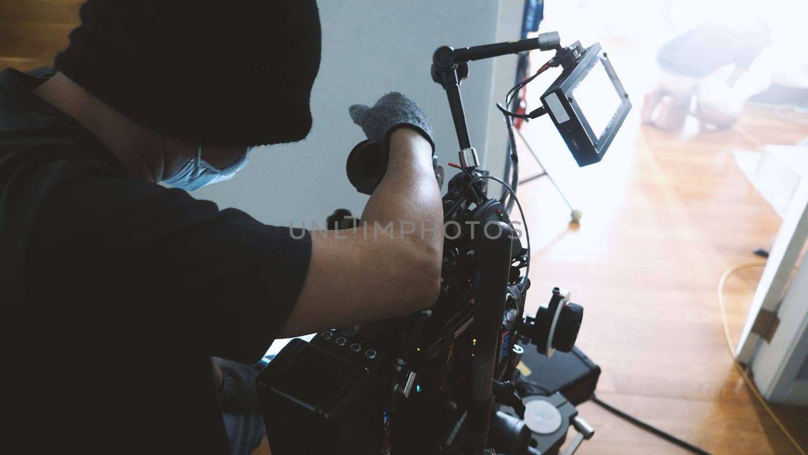 Video camera ultra high definition on pan and tilt head professional tripod with rig and gimbal operated by film crew team that recording or shooting tvc movie at location with monitor.