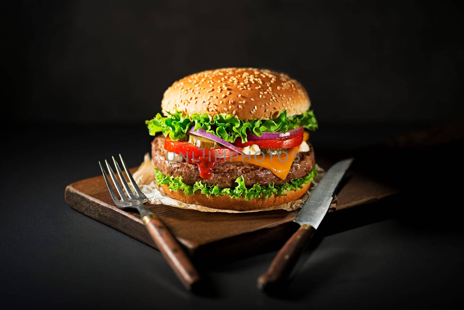 Eating Homemade hamburger or burger with fresh vegetables and cheese