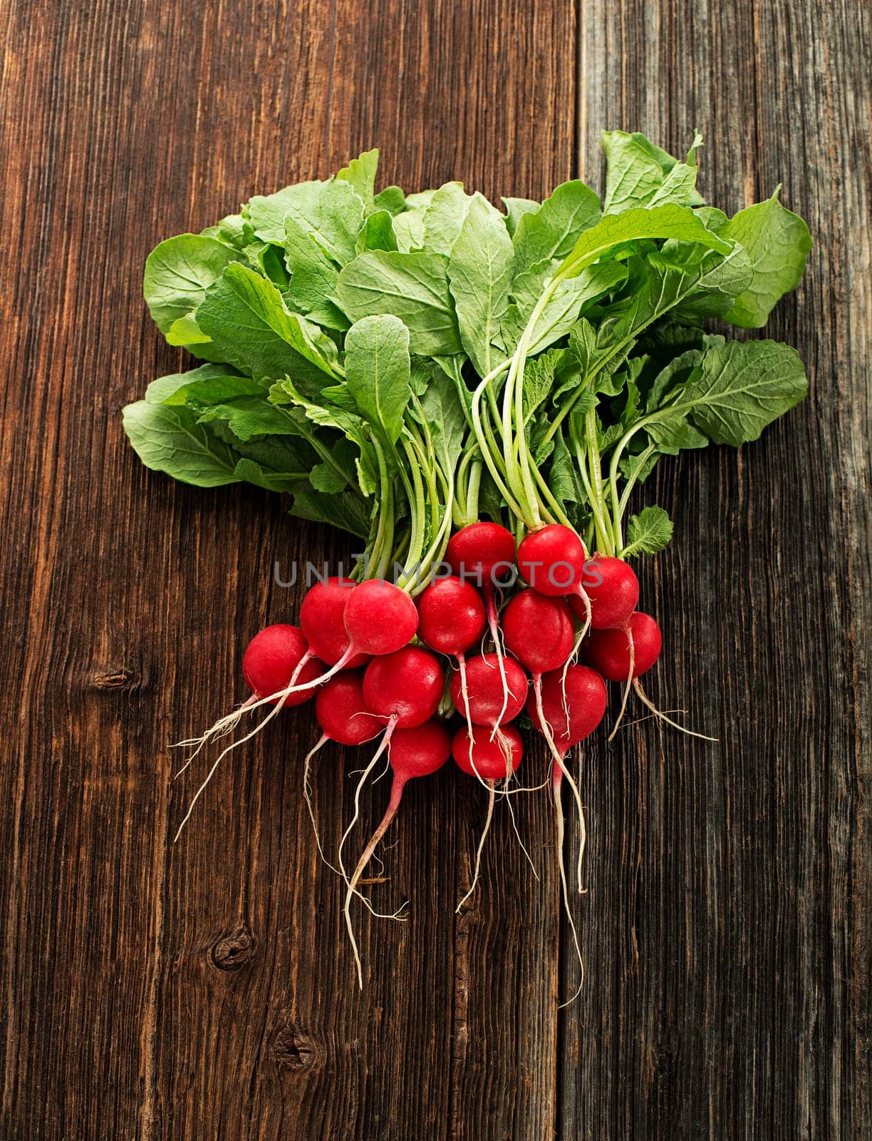 Fresh red radishes on wooden background close up
