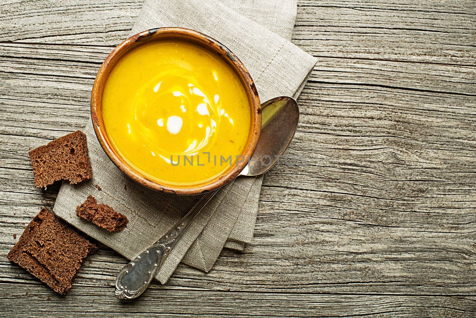 Healthy vegetable yellow cream soup on wooden background