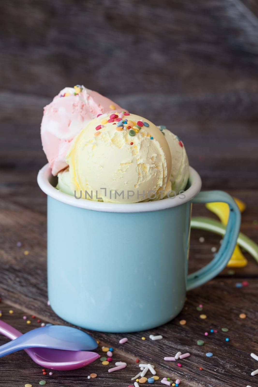 Colorful ice cream balls in enamel cup with sugar sprinkles