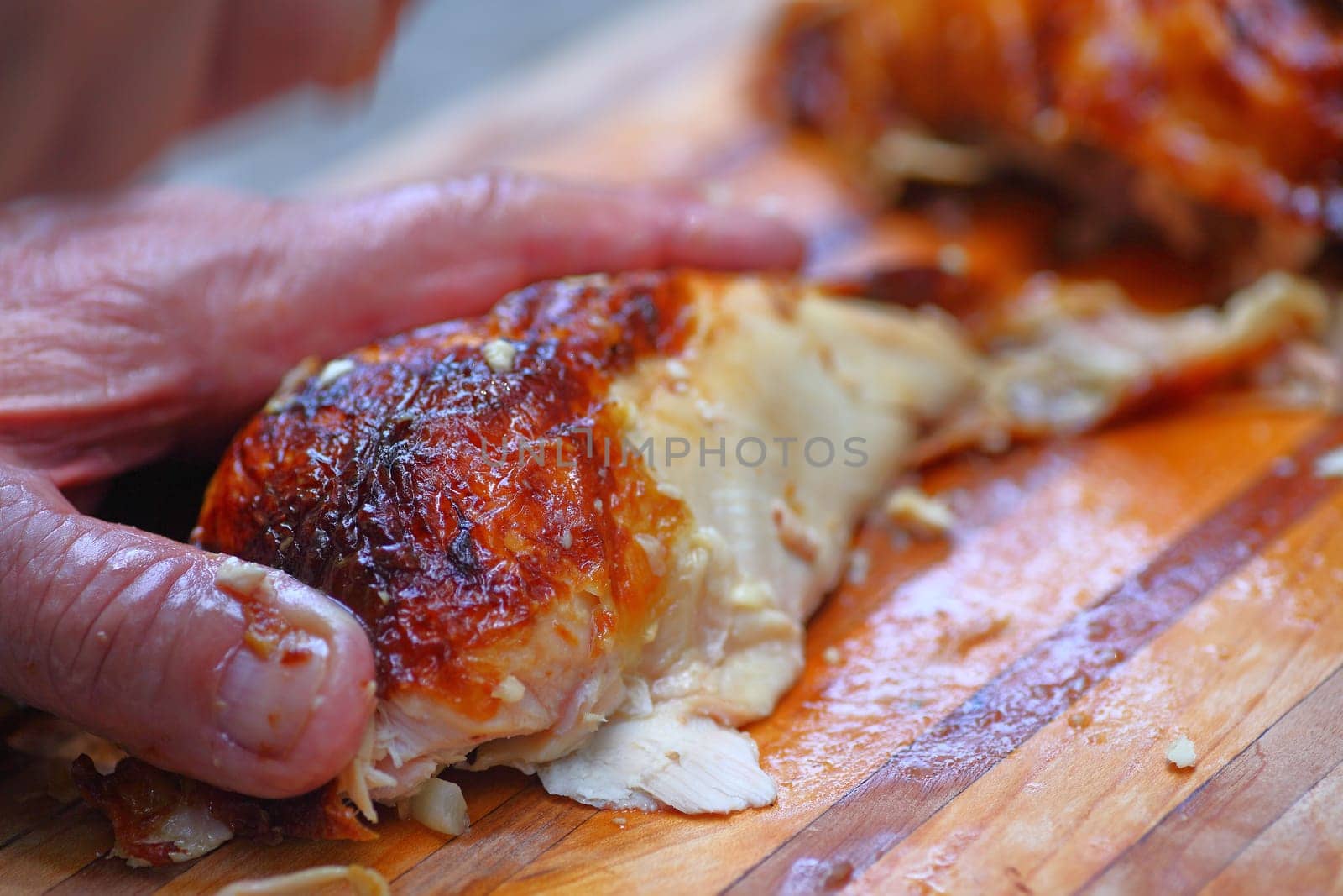 A man prepping a roast chicken breast on a cutting board