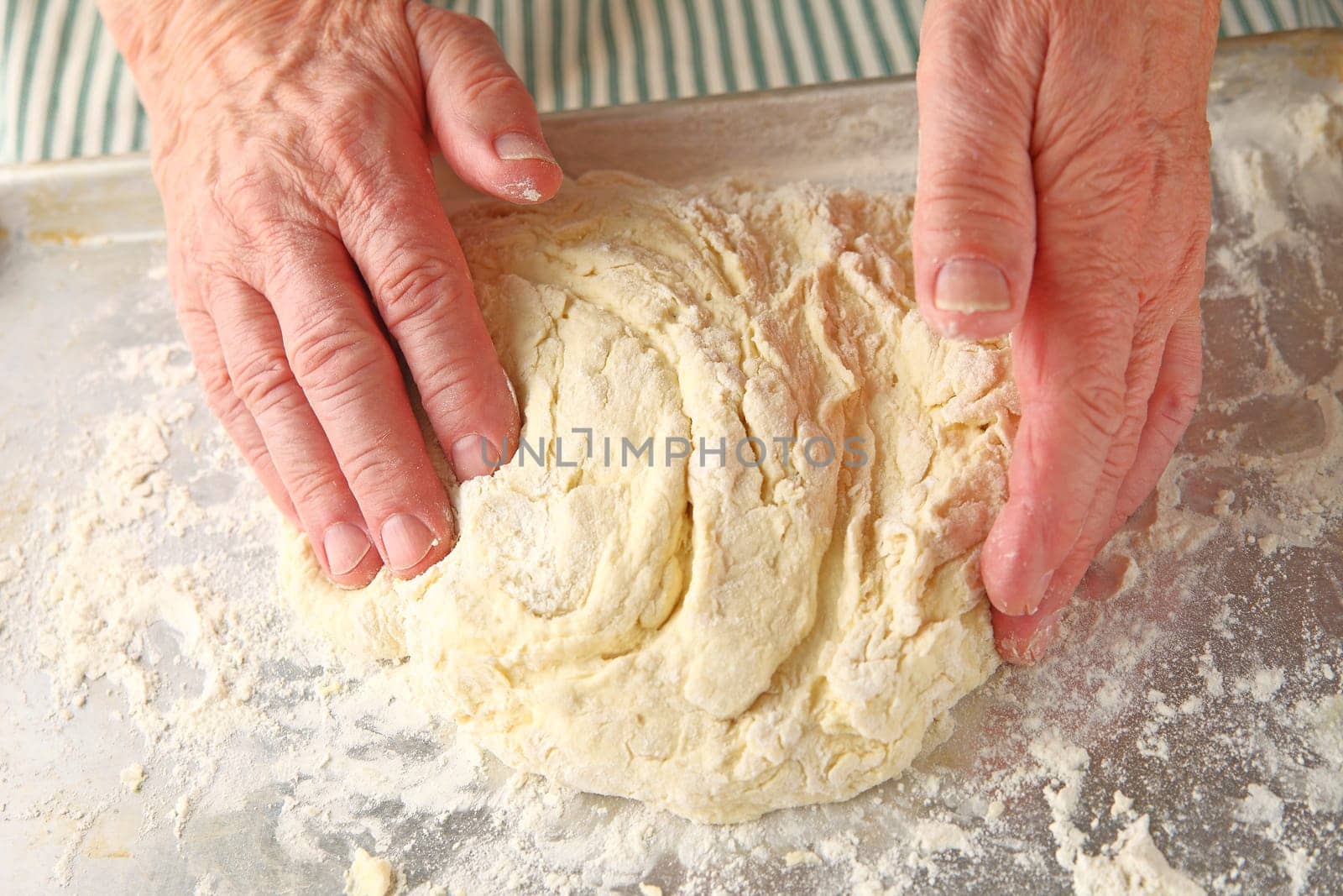 Male cook kneads dough for baking powder biscuits