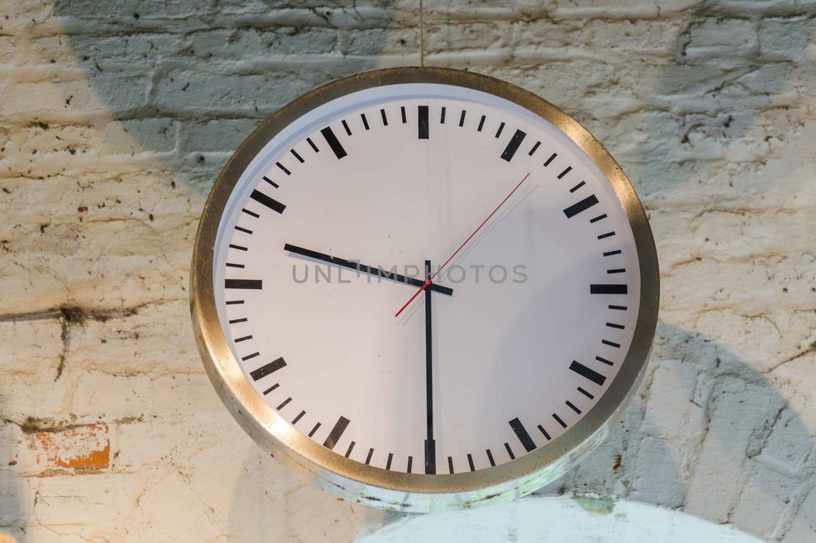 Big old clock in an old factory in front of a window