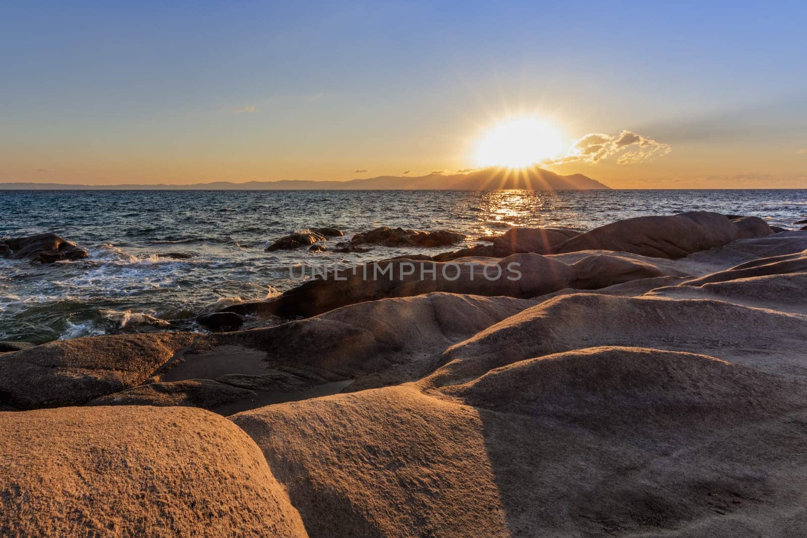 Vourvourou - Karidi beach with mount Athos in the background surprised at sunrise.