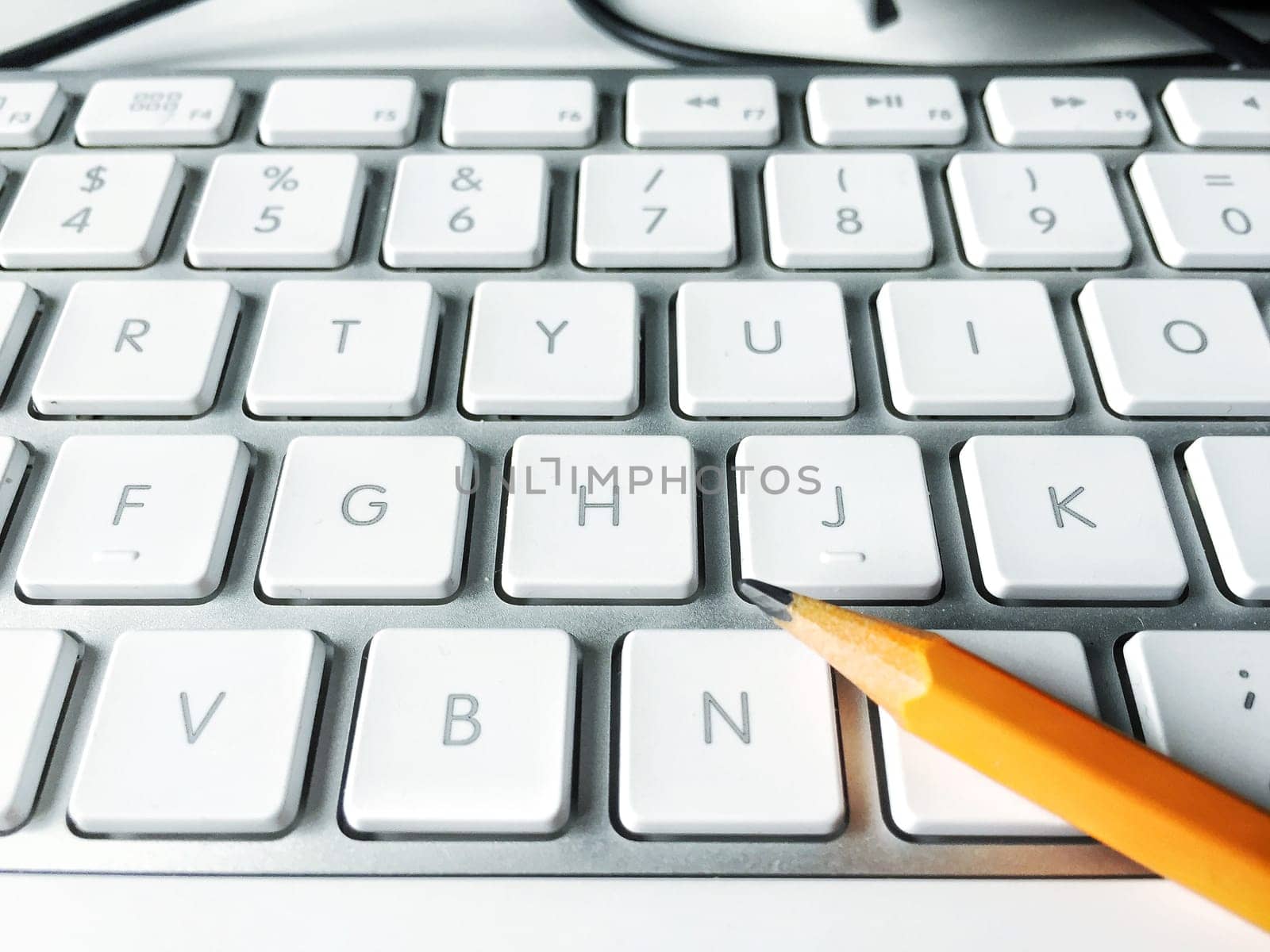Orange Pencil over a white computer keyboard