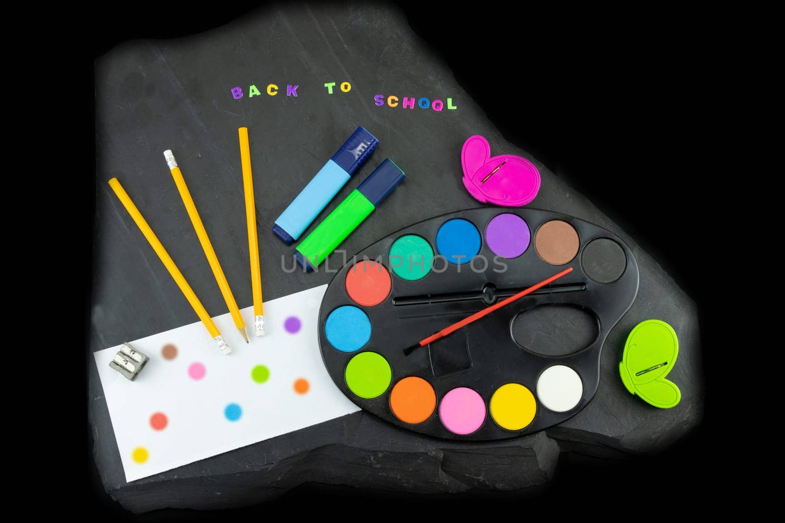 Closeup of colorful school supplies with copy space on blackboard background. Back to school written with colorful letters on blackboard. Concept education..