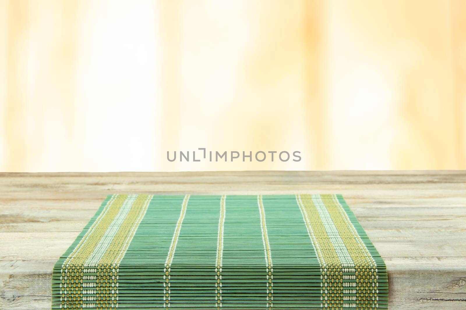 Empty table with green tablecloth over bright background. For your food and product display montage