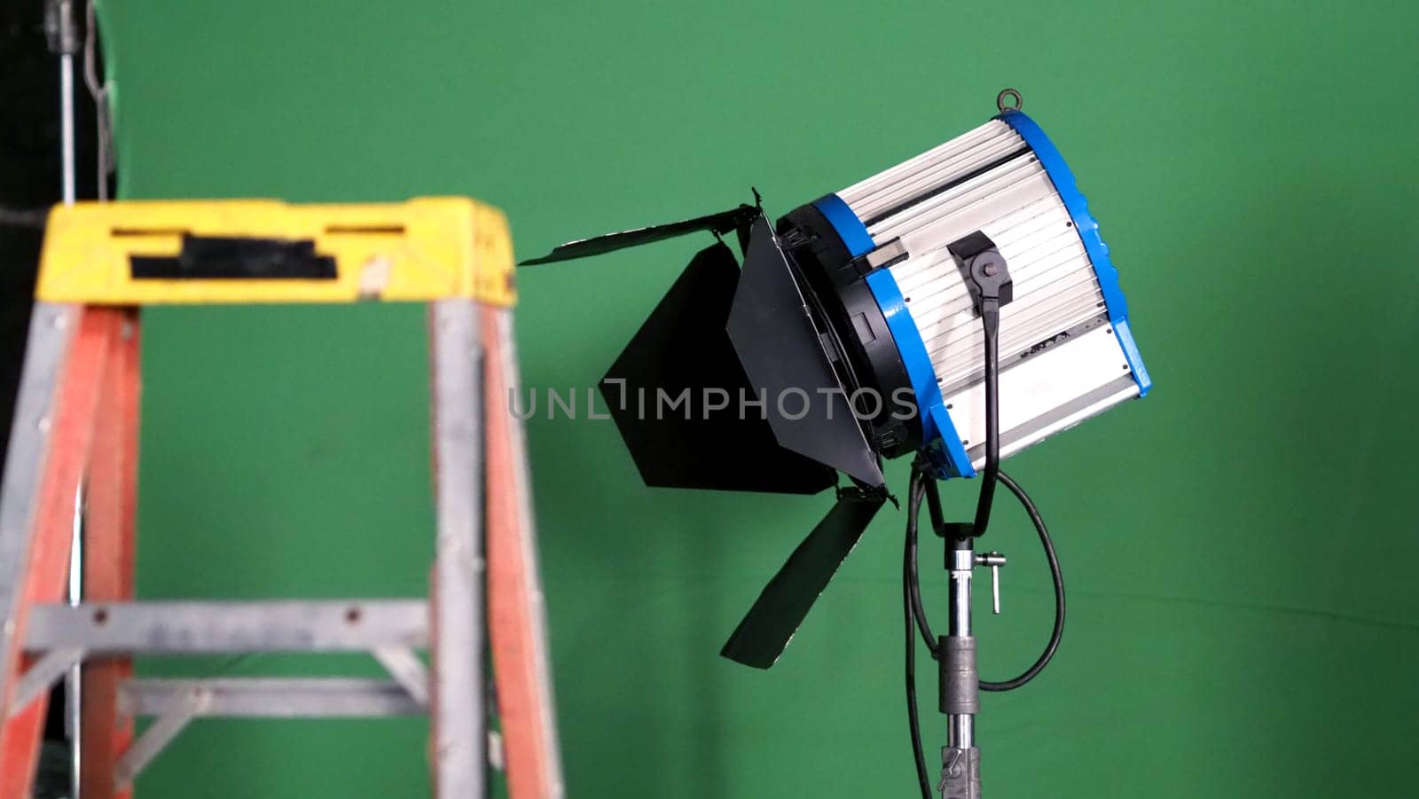 Big studio lighting kit 5000 watt with soft box on tripod and professional green screen background chroma key post production technique shooting or filming for movie or video commercial set up.