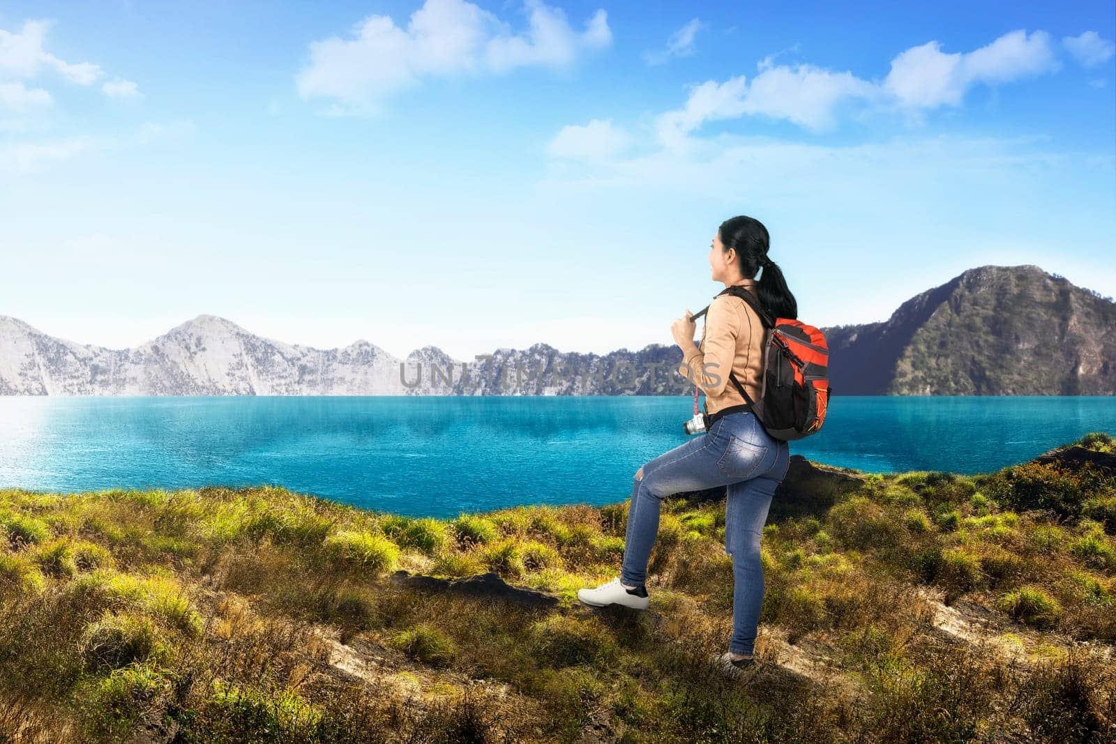 Young asian traveler woman with backpack looking at lake view on the mountain
