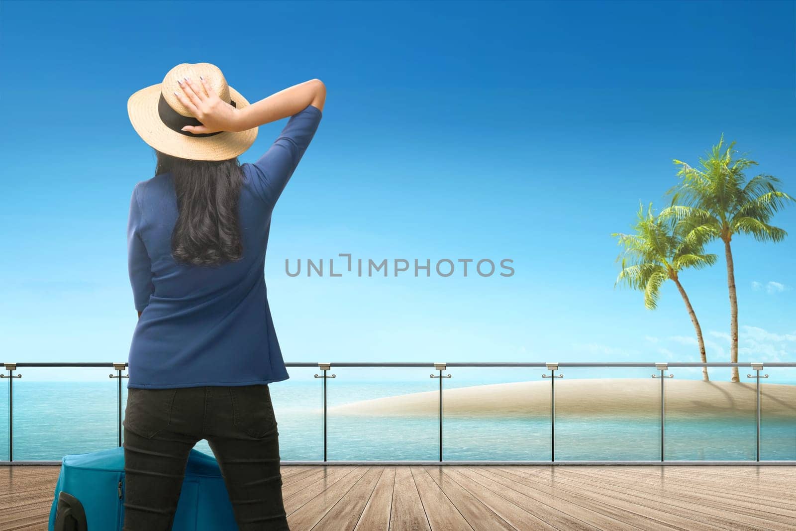 Back view of asian female traveler looking at ocean view from terrace
