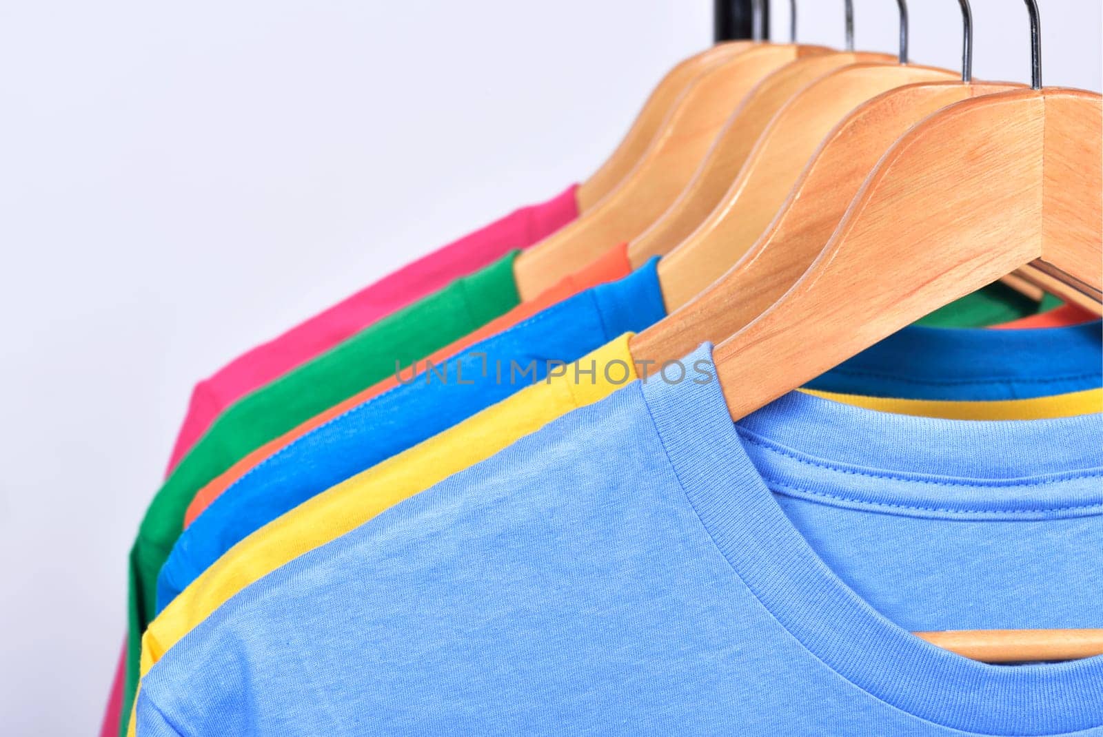 Colorful clothes hang on a shelf after washing isolated over white background