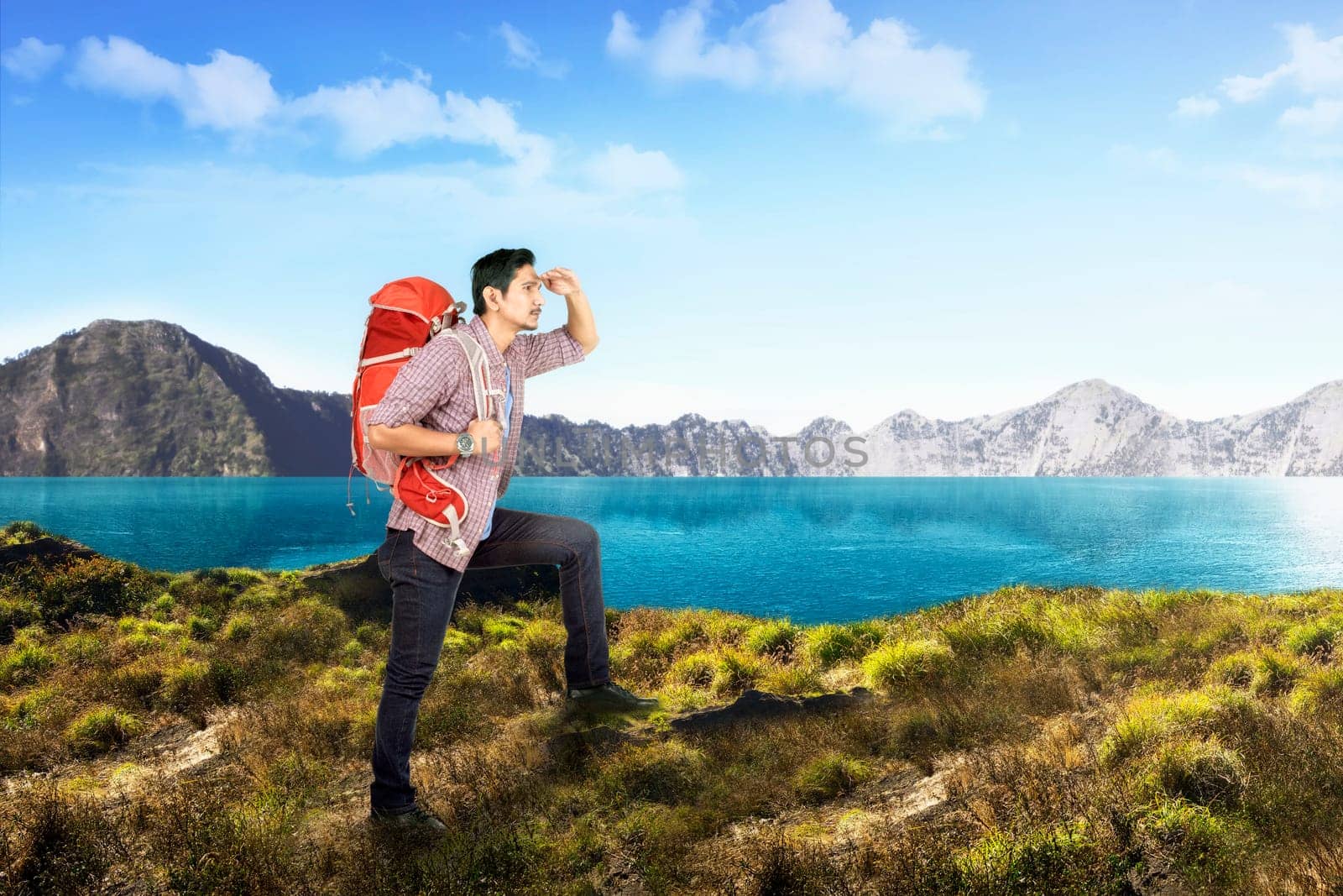 Attractive asian male traveler looking at lake view at mountain