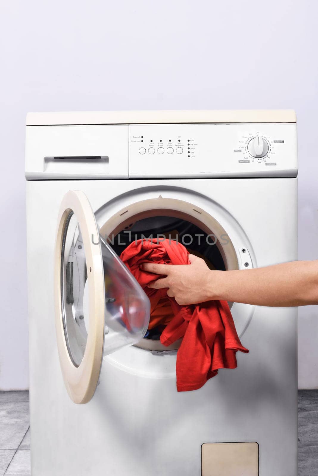 Man hands put the clothes into washing machine. Home appliances