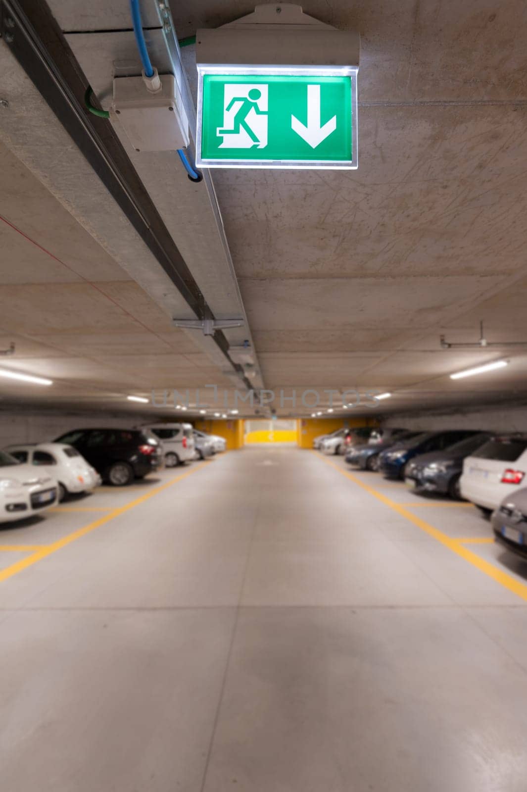 Green emergency exit sign on white in the parking car.  image for background, copy space, objects, illustration and article