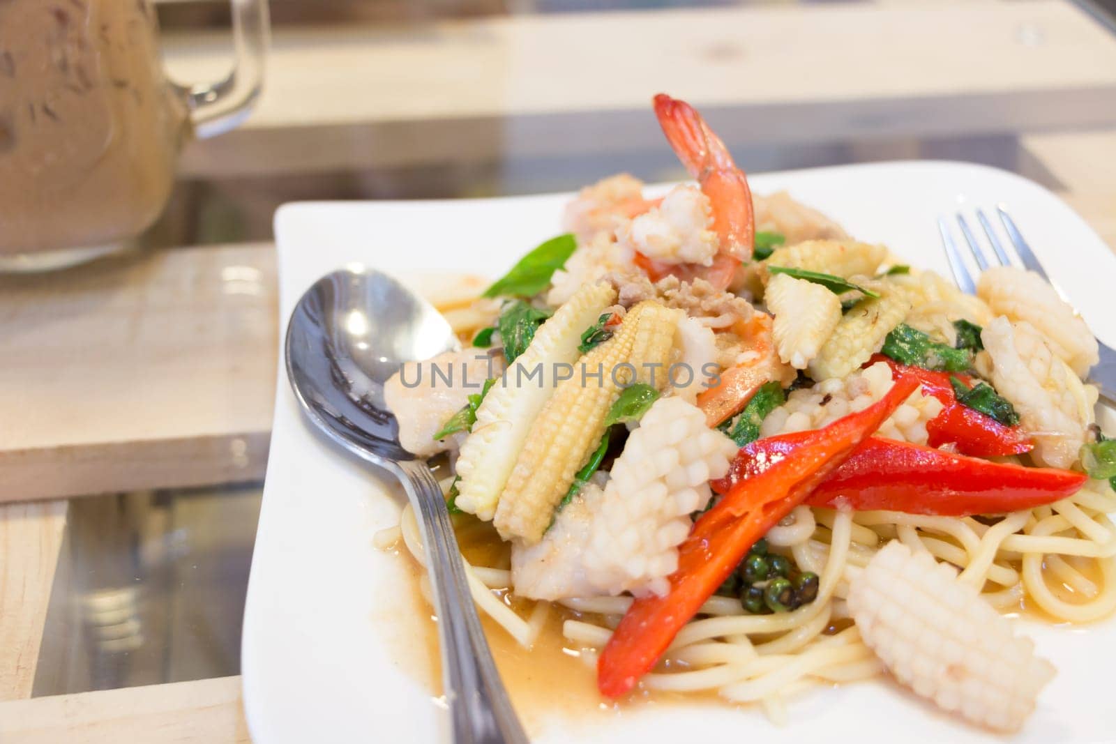 Spicy Spaghetti seafood in white dish on the wood table