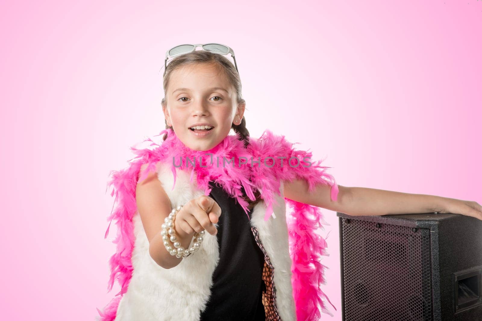 a pretty little girl with a pink feather boa on pink background