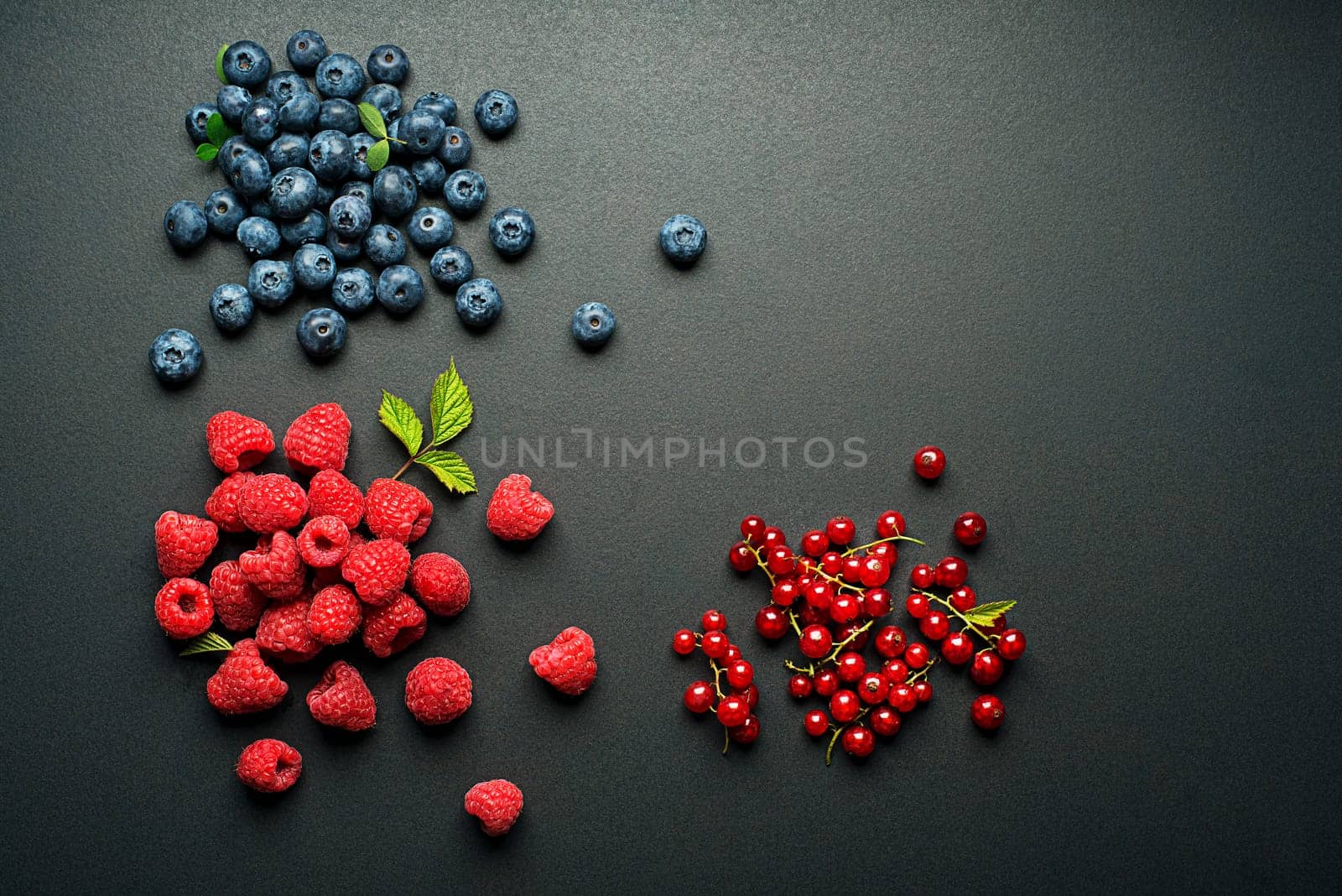 Mix of fresh berries on black background close up