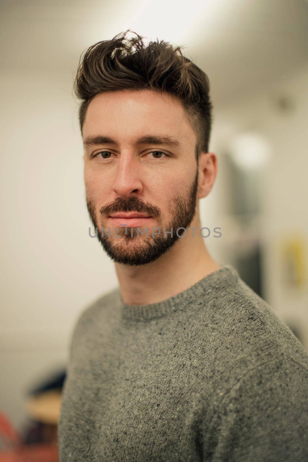 Front view of a young male adult looking at the camera while he gets a portrait taken.
