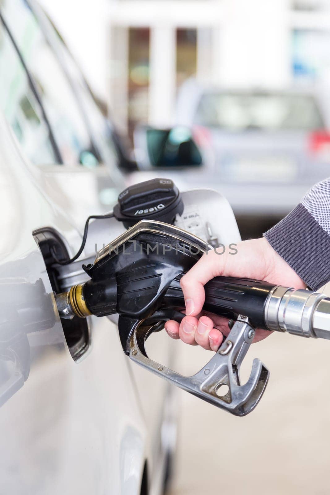 Pumping gas at gas pump. Closeup of man pumping gasoline fuel in car at gas station.