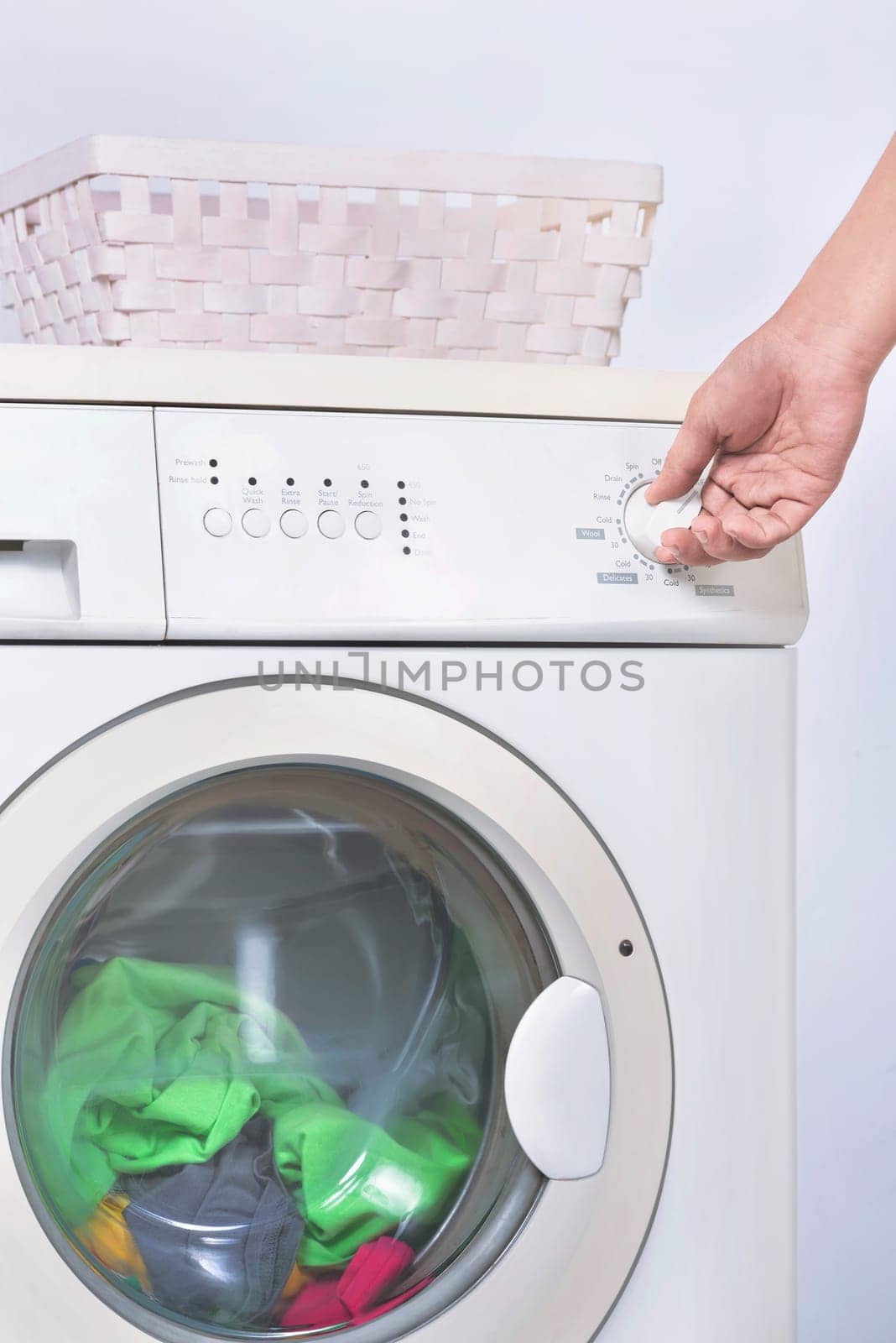 Male hand setting the program on washing machine. Home appliance