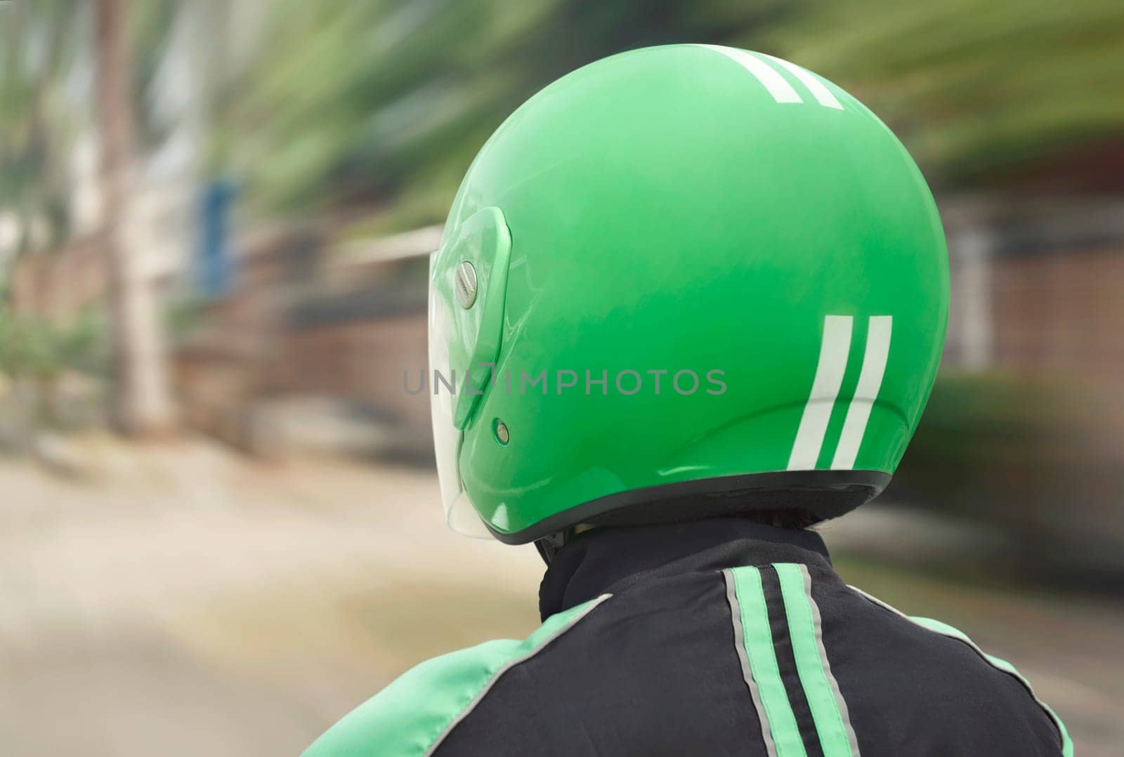 Rear view of motorcycle taxi ride with fast on the urban street