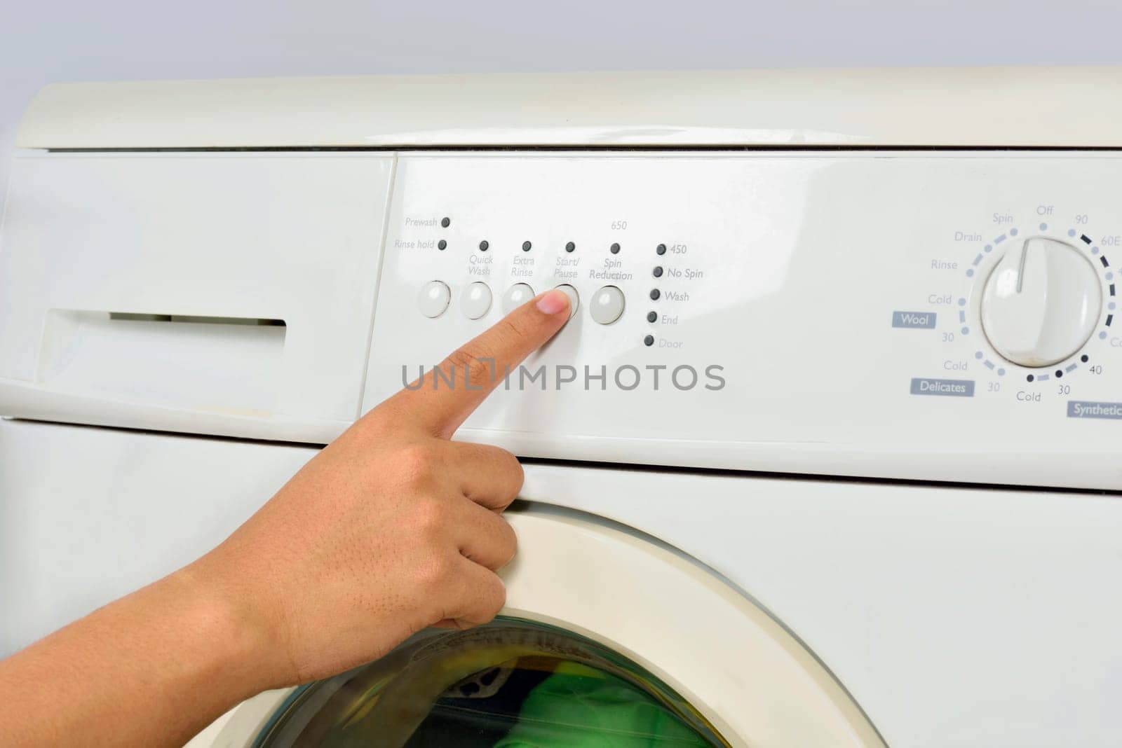 Closeup of hand push the button on washing machine isolated over white background