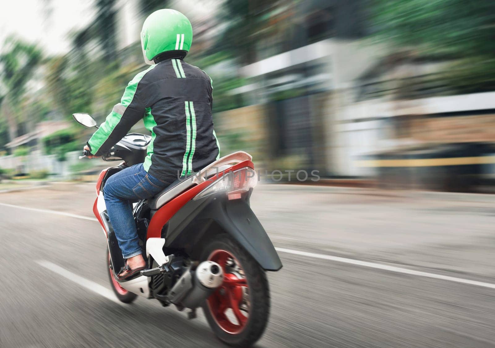 Rear view of motorcycle taxi ride with fast on the urban street