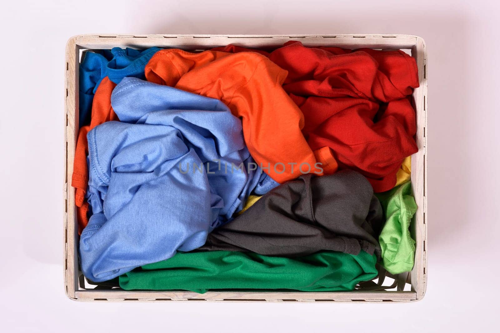 Top view of laundry basket with dirty clothes isolated over white background