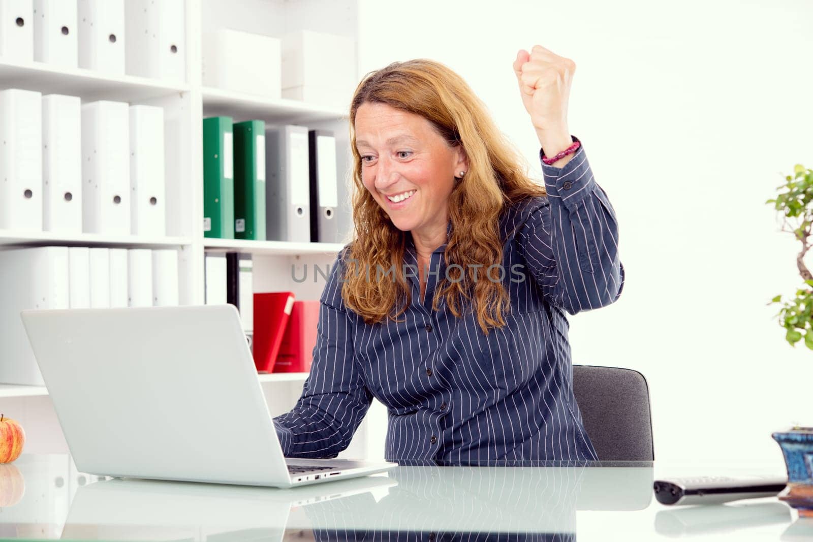 young amazed business woman at his desk
