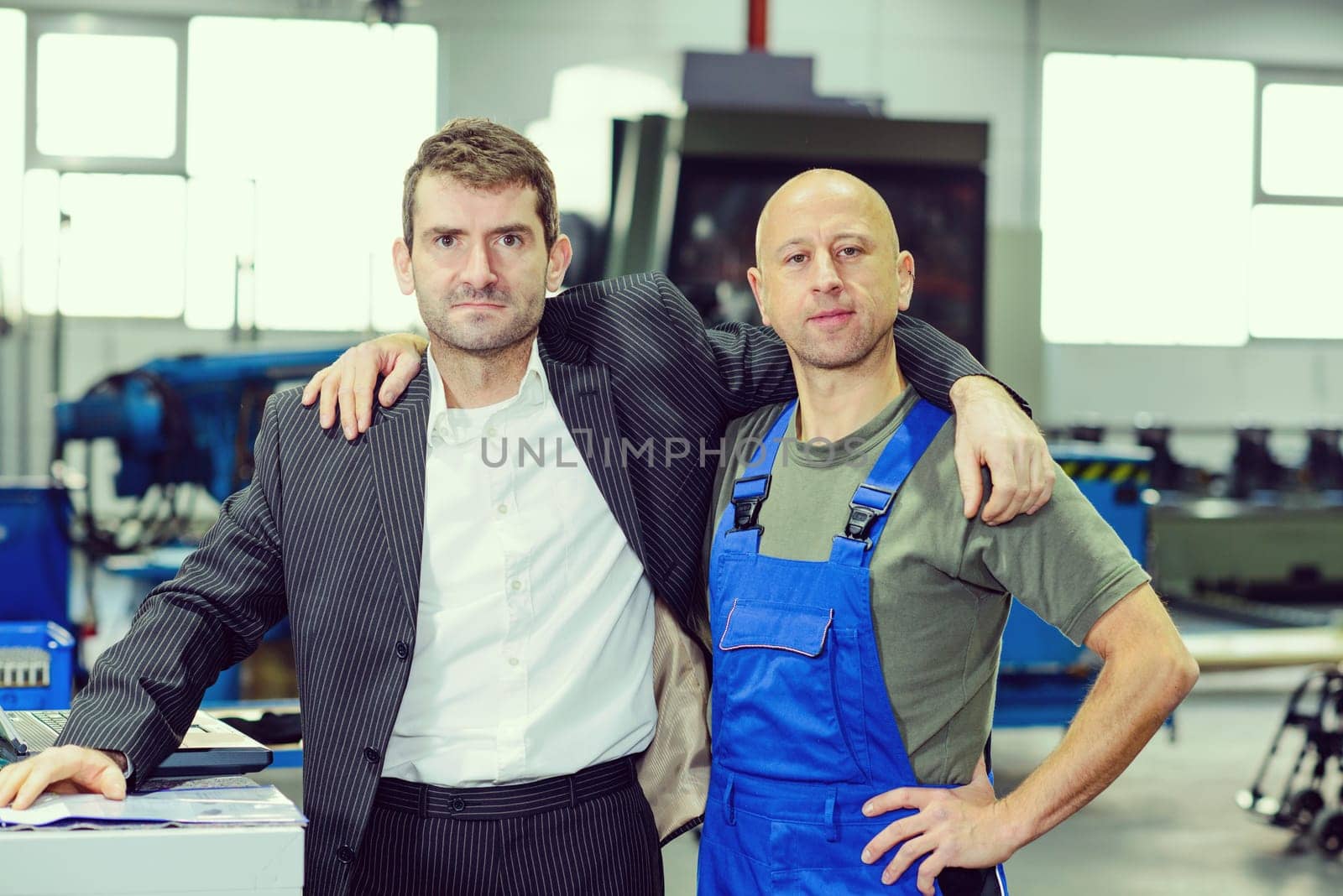 hugging-  boss and worker on work bench