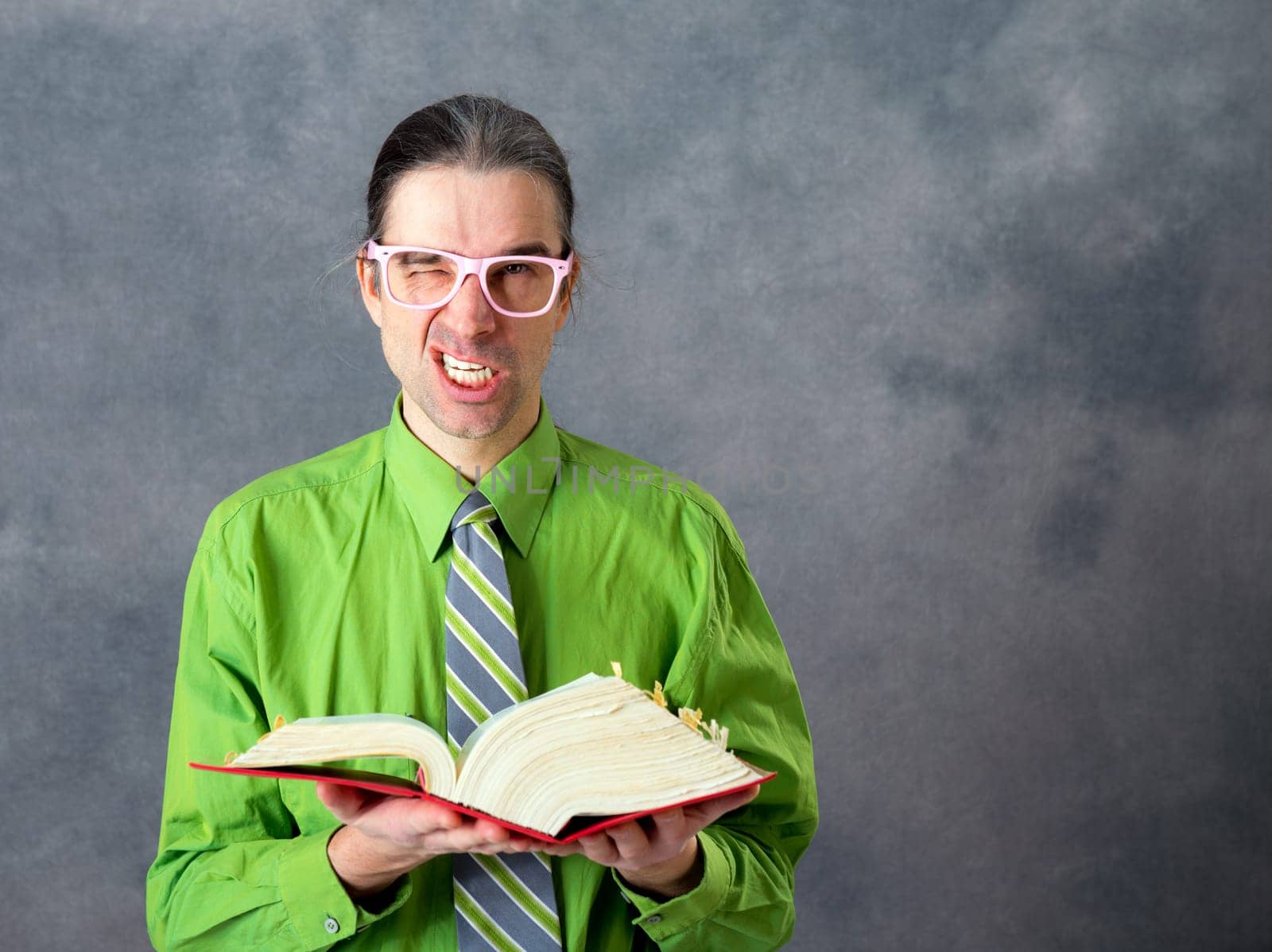 angry lawyer in green shirt and necktie with statute book and pink glasses