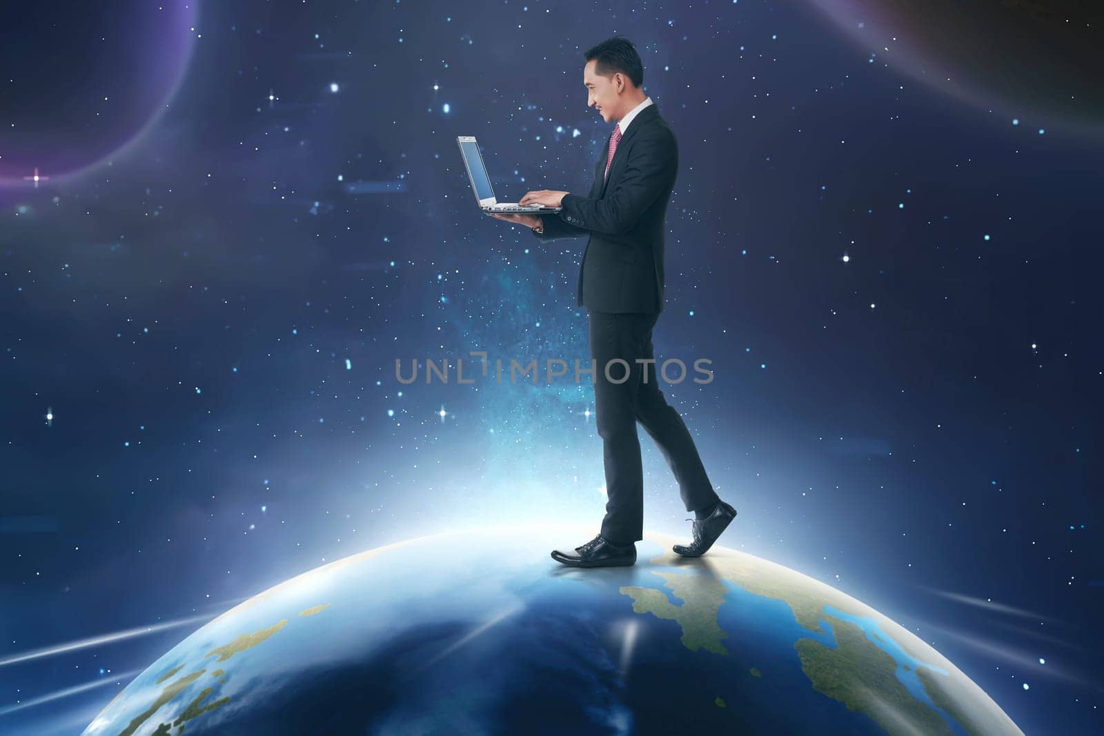 Asian businessman using laptop while walking on earth with outer space background