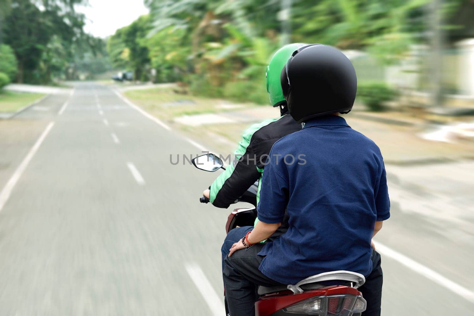 Portrait of motorcycle taxi driver delivering the passenger to his destination on the city