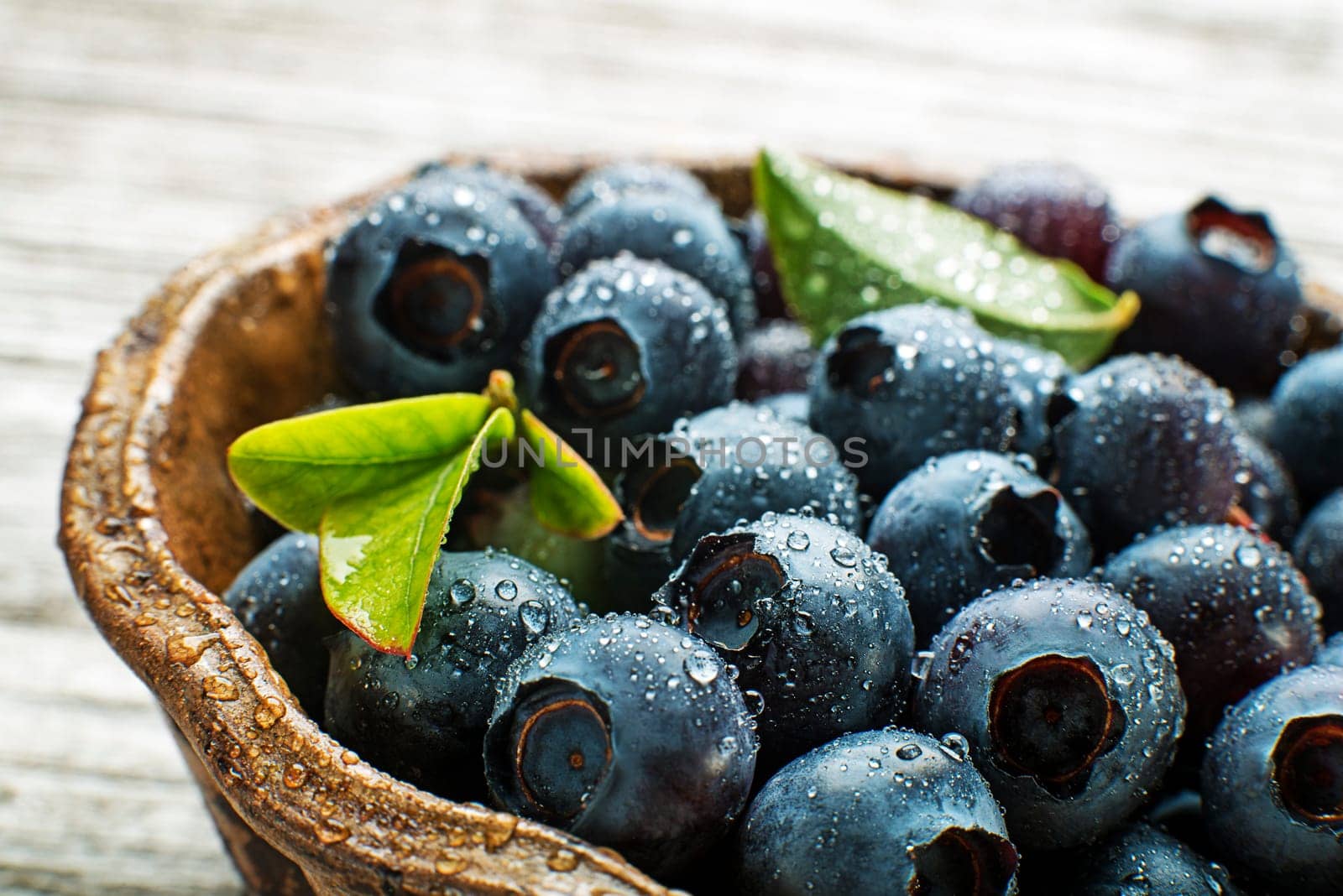 Fresh blueberries with leaf in a bowl close up. Concept for healthy eating and nutrition