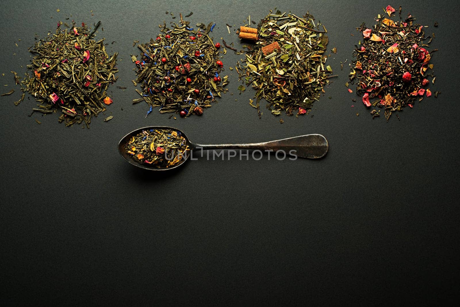Dry tea collection and spices of different types on black background