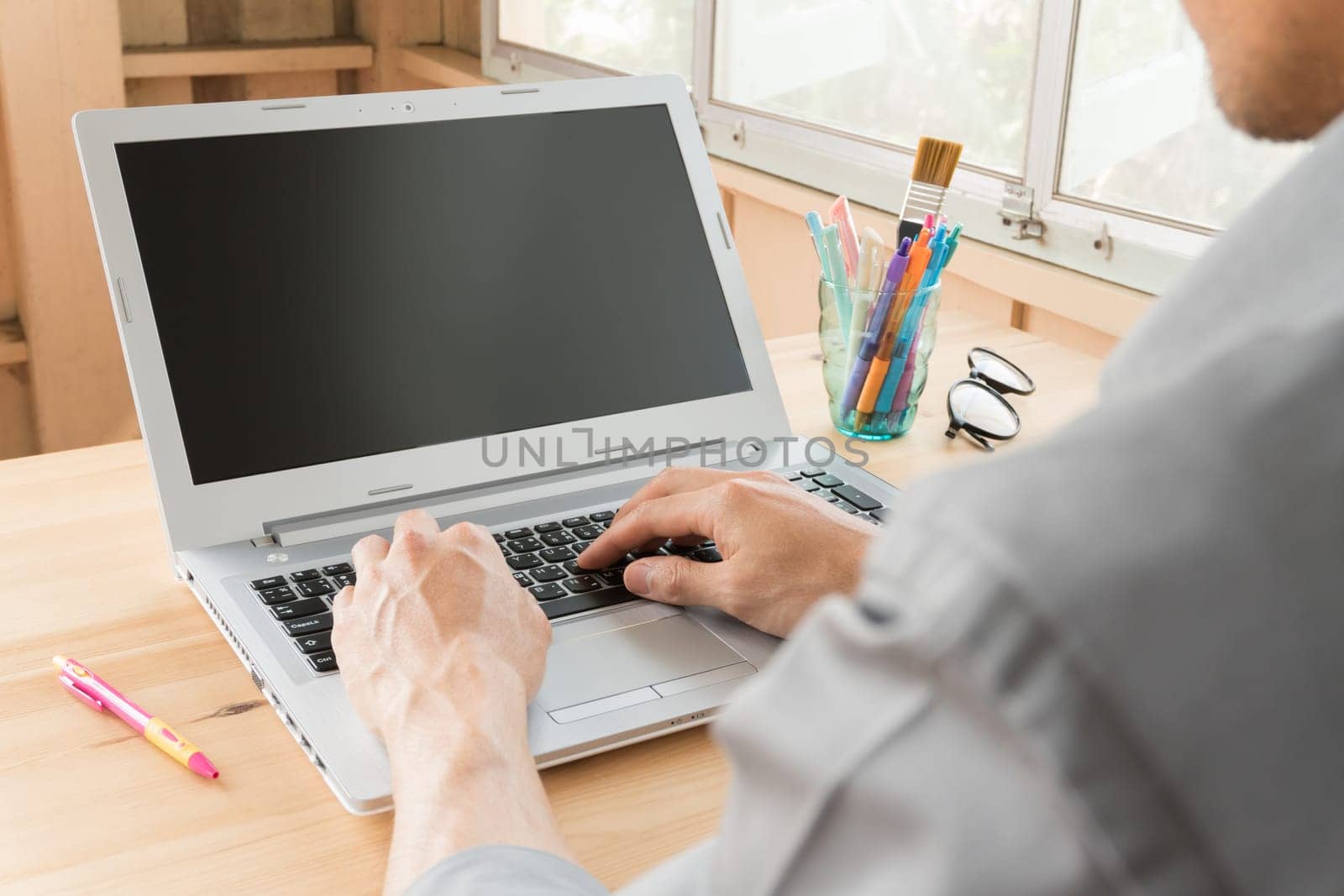 Gray shirt businessman typing laptop or notebook in home office. Small business SME or start up businessman concept. Business and .technology about communication or contact