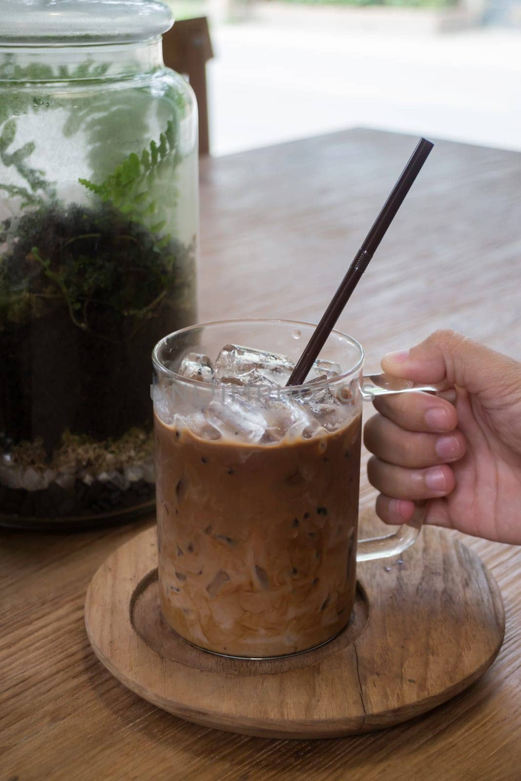 Hand on glass of iced coffee mocha, stock photo