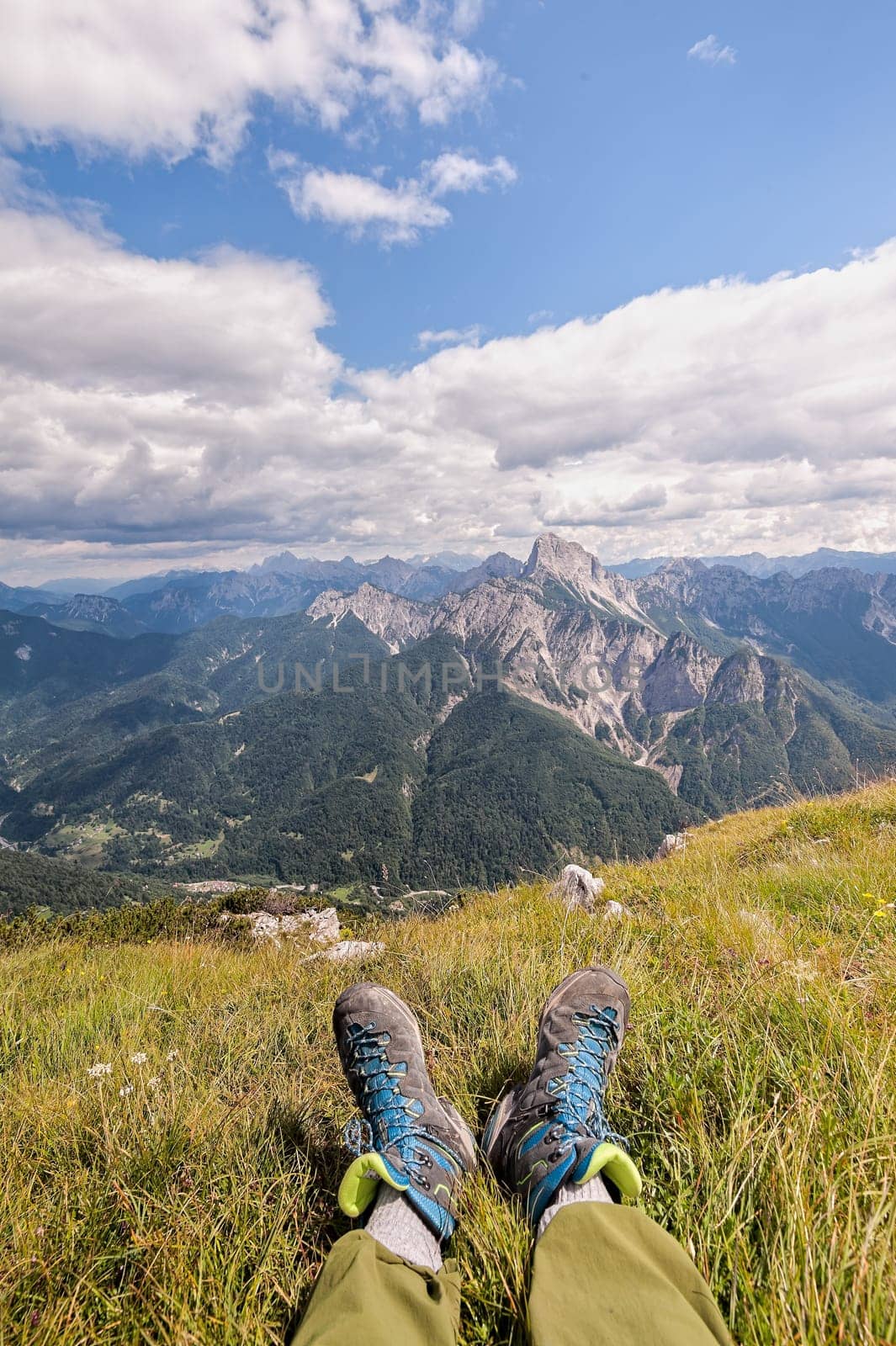 Hiker boots. Rambler having fun and enjoying wonderful breathtaking mountain view. Freedom concept. Italian Alps. Friuli Venezia Giulia.  Concept of adventure.