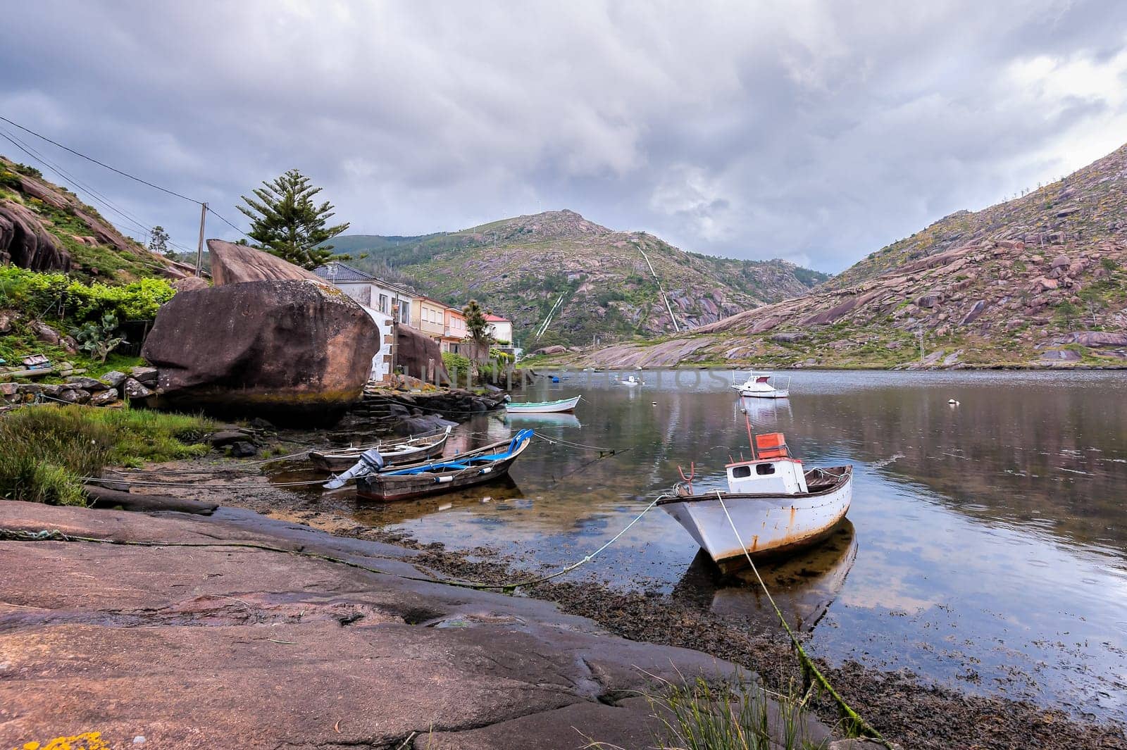 Landscape with fishing boats moored  on shore. Galicia Spain.