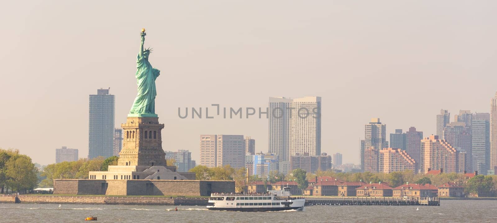 Statue of Liberty with Liberty State Park and Jersey City skyscrapers in background, USA.