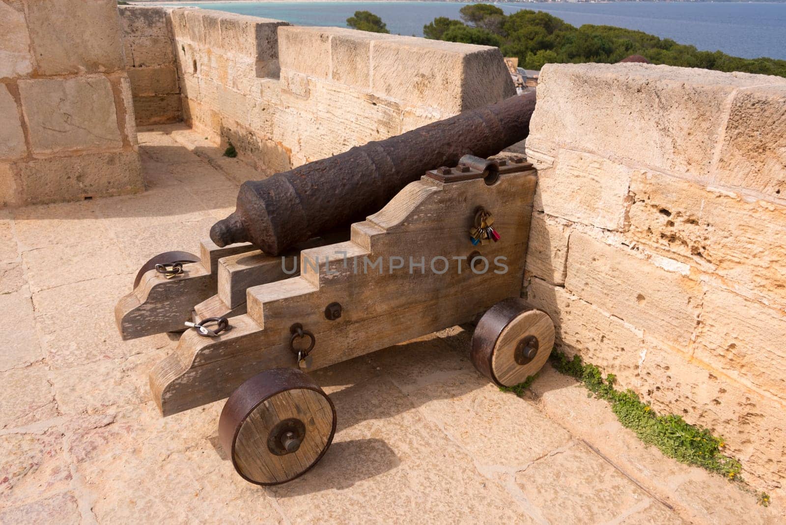 Old antique iron cannon on the old defence tower of Punta de N'Amer near Sa Coma, on the Spanish Balearic Mediterranean island of Mallorca