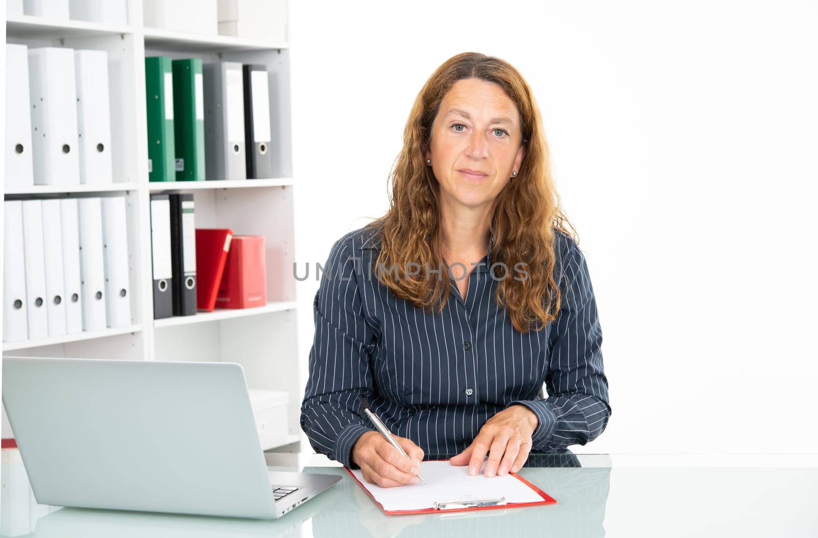 brown-haired  businesswoman working and writing  in the office