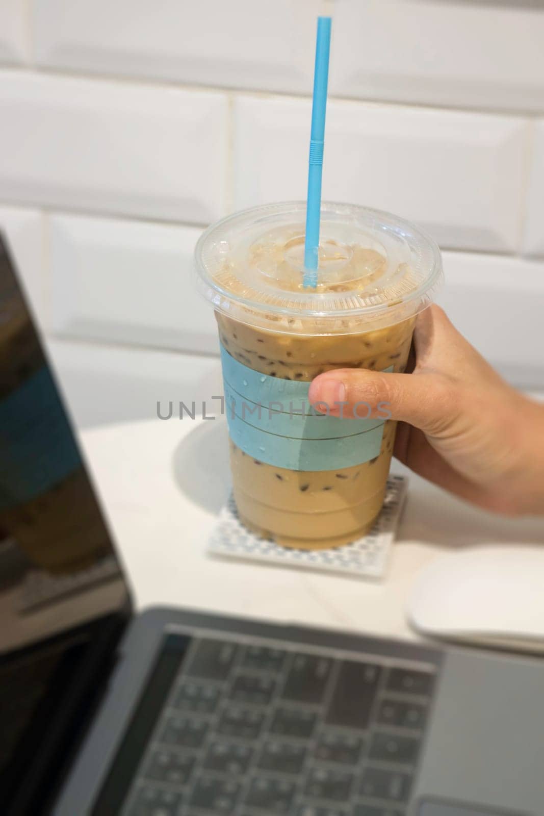 Woman holding plastic glass of iced coffee with milk, stock photo