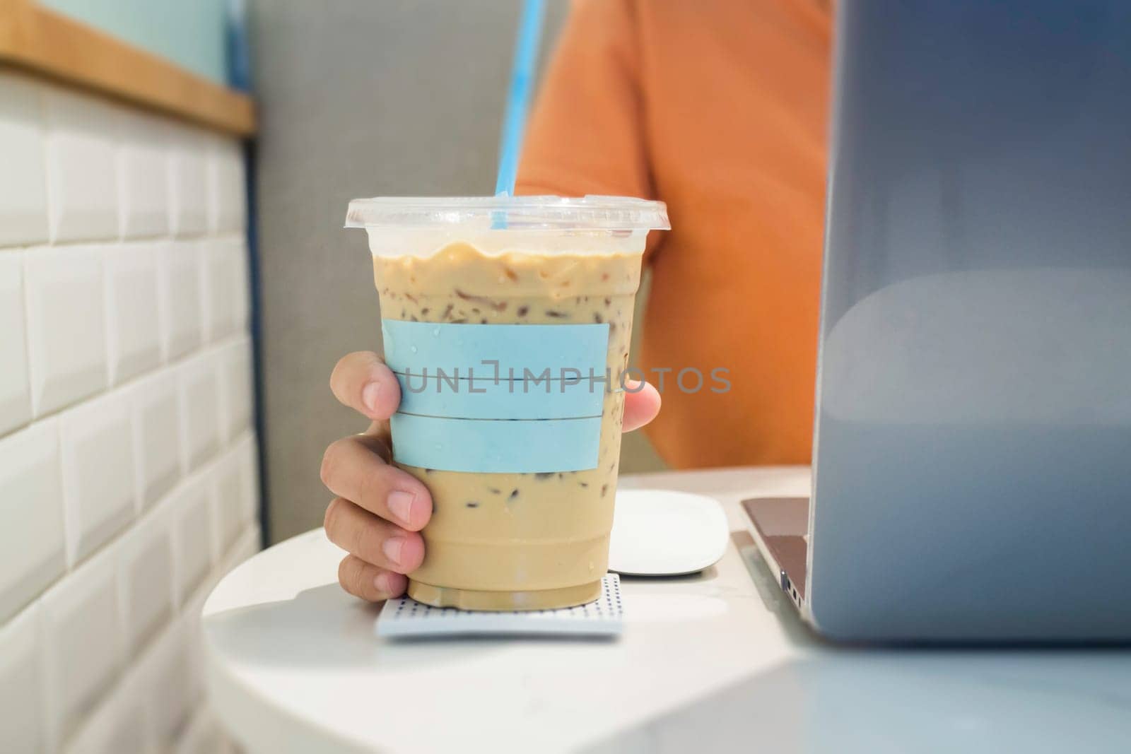 Woman holding plastic glass of iced coffee with milk, stock photo