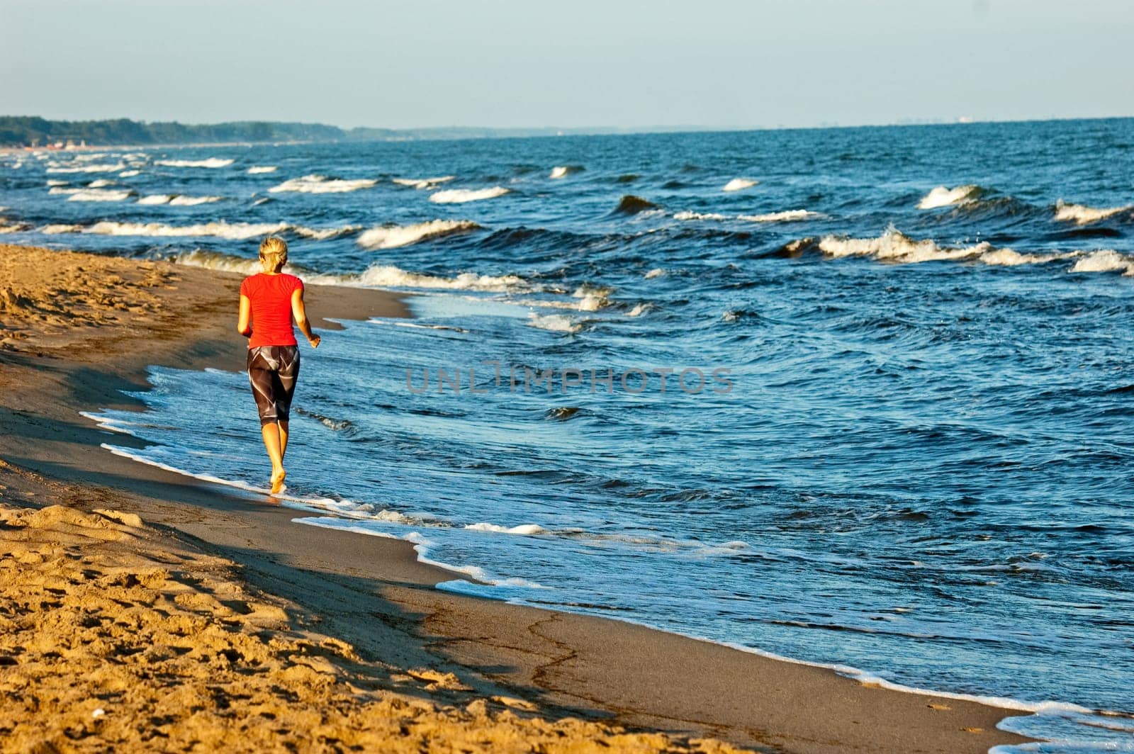 young beautiful sportswoman doing exercises on beach