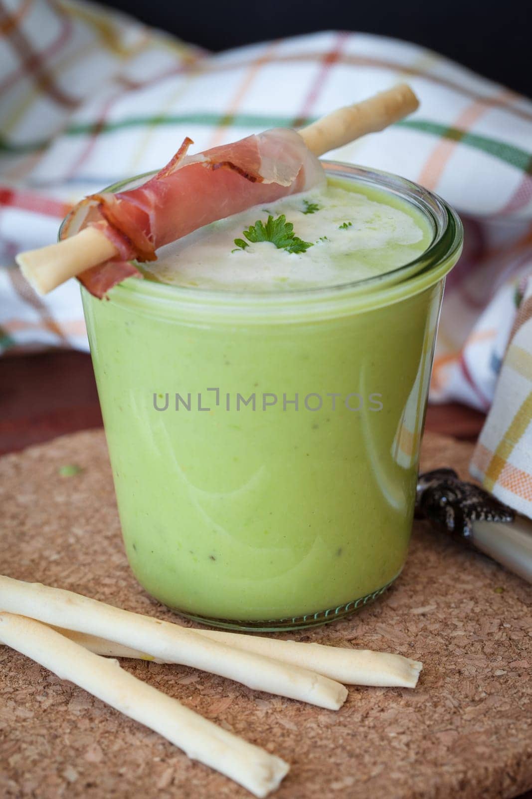 Homemade creamy pea soup and bread sticks with smoked ham