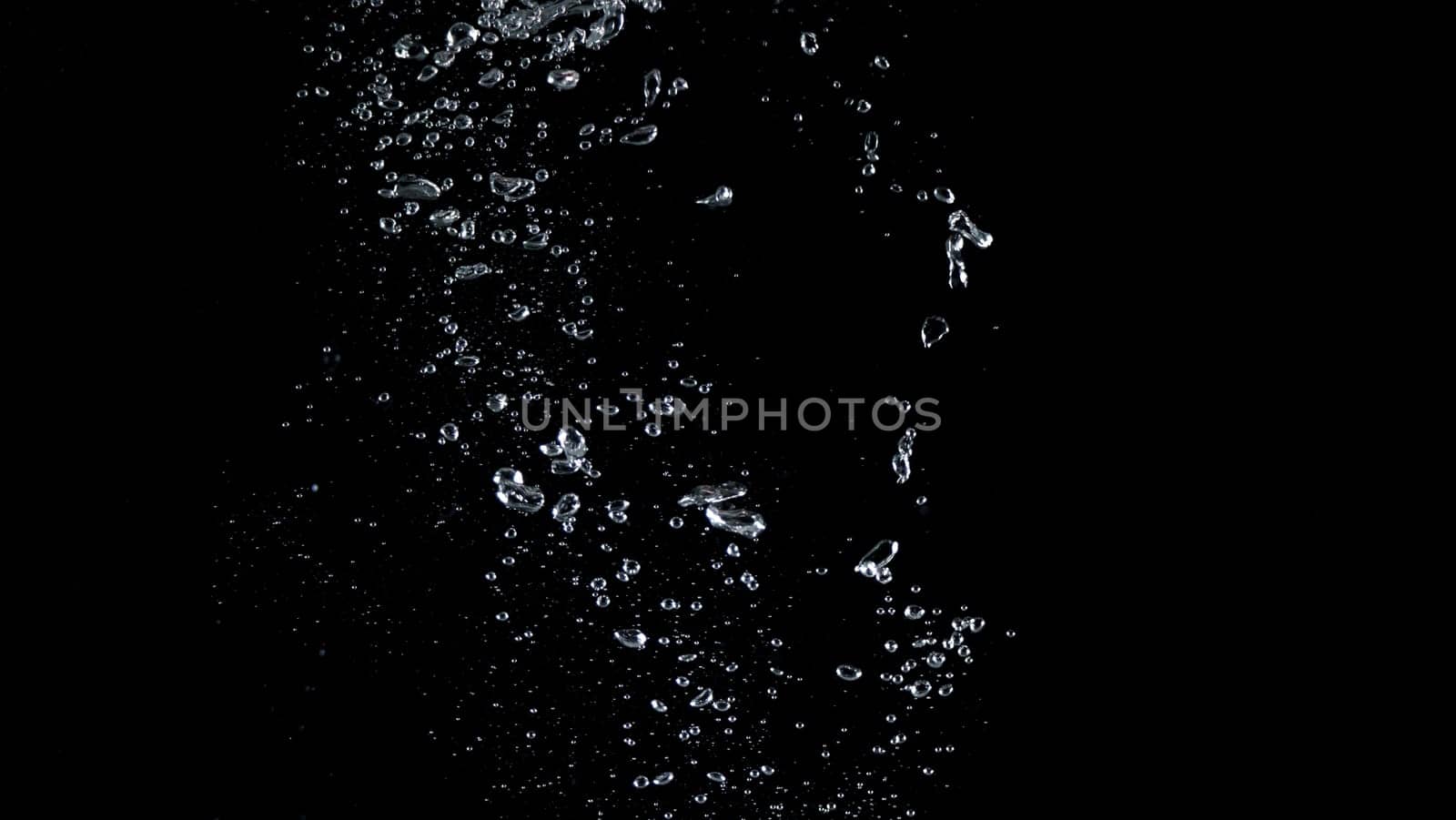Close-up images of soda water splashing in the water to many little bubbles that make it feel like refreshing and black background