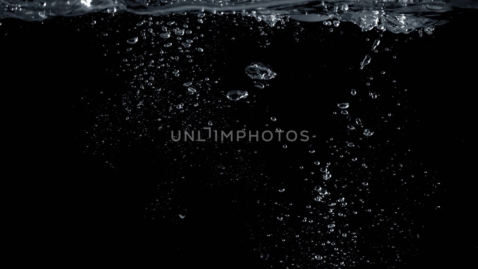 Close-up images of soda water splashing in the water to many little bubbles that make it feel like refreshing and black background